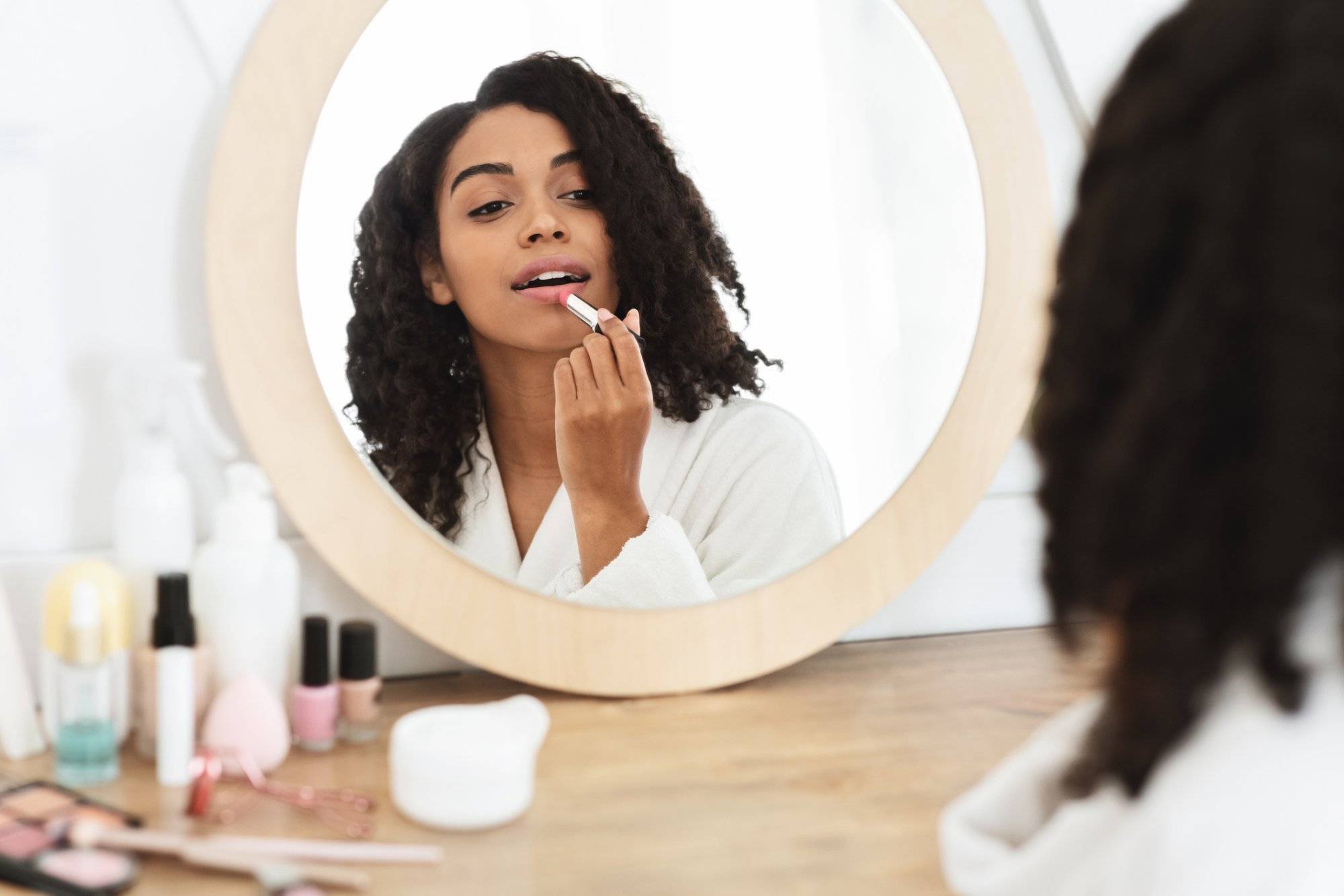Beauty Portrait Of Black Girl Applying Pink Nude Lipstick In Front Of Mirror Prep for Fall Date Night in Garland at Northstar Plaza