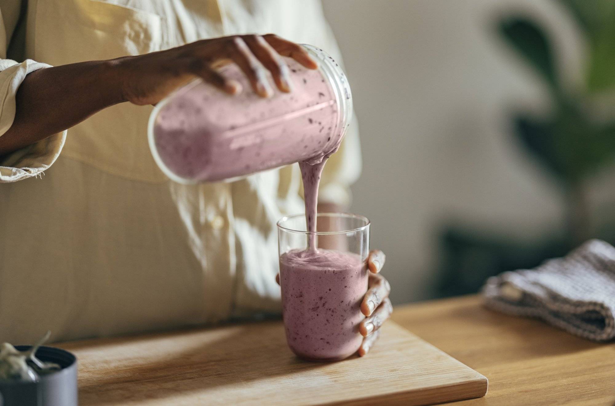 Anonymous Afro-American Woman Pouring a Smoothie Into a Glass Stay Healthy This Holiday Season at Nutrition With A Twist in Garland