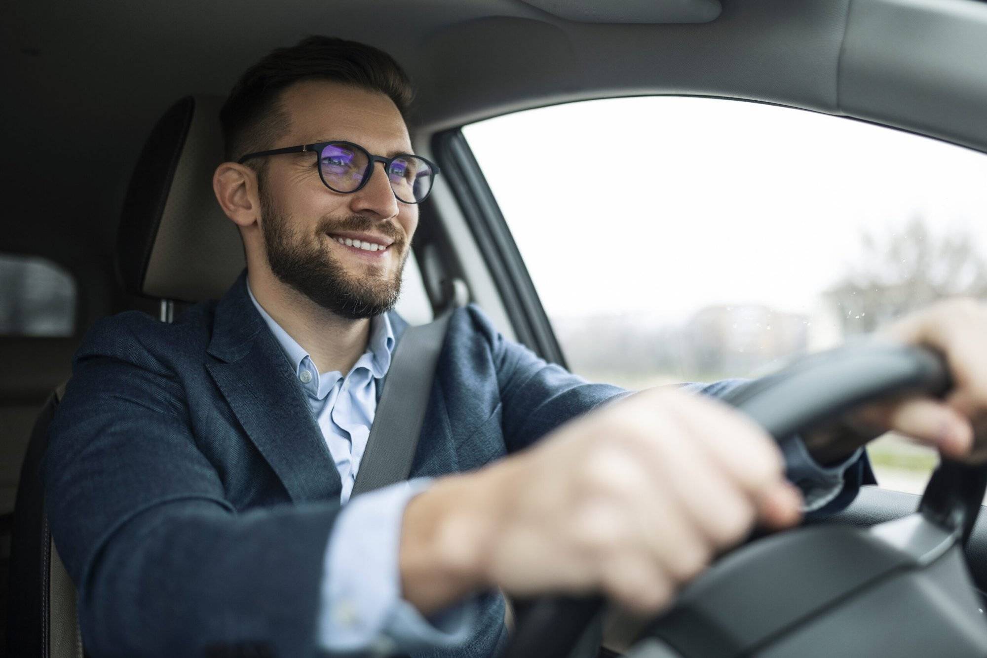 Smiling businessman driving his car Businessman driving his car